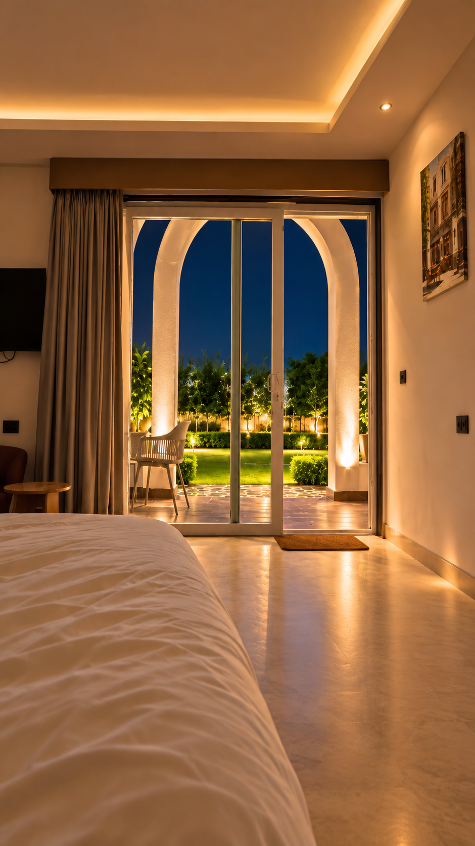 Suite bedroom opening onto the lit garden at night